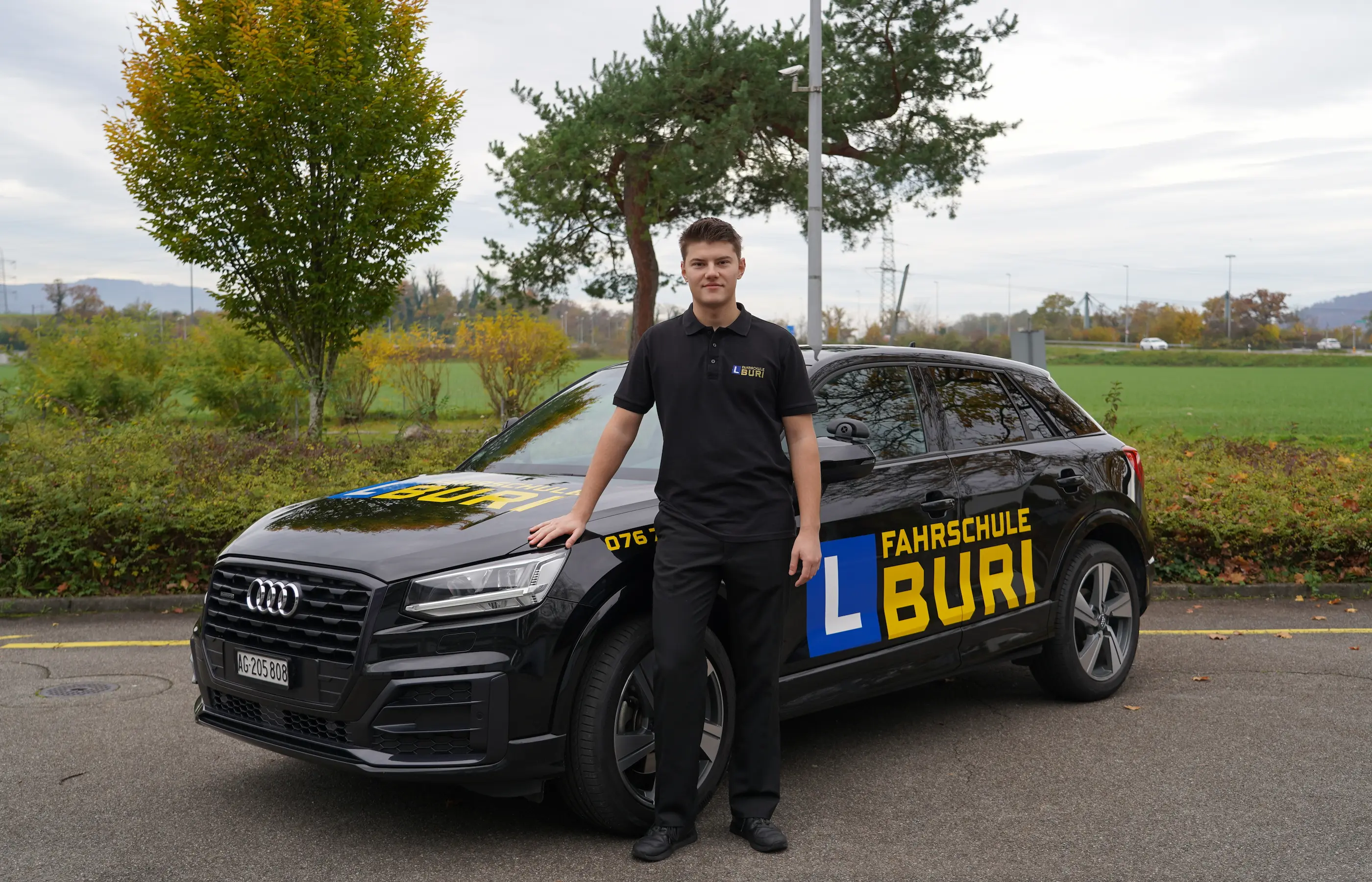Kerim vor einem Fahrschule Buri Fahrzeug