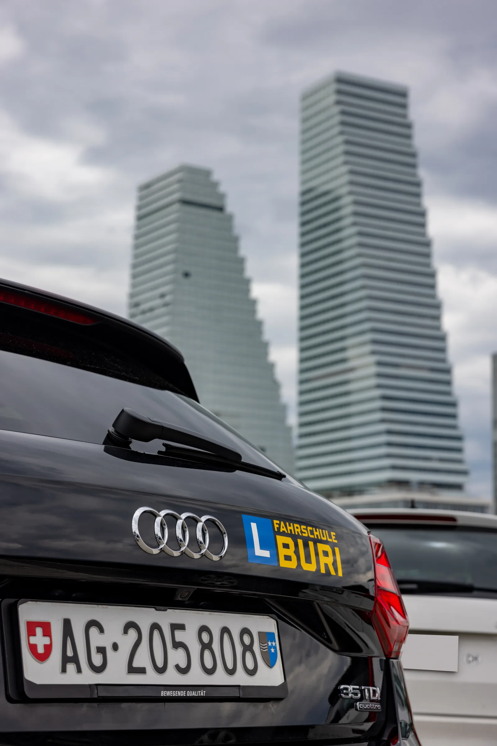 Fahrzeug der Fahrschule Buri mit eingeschaltetem Licht in der Dämmerung