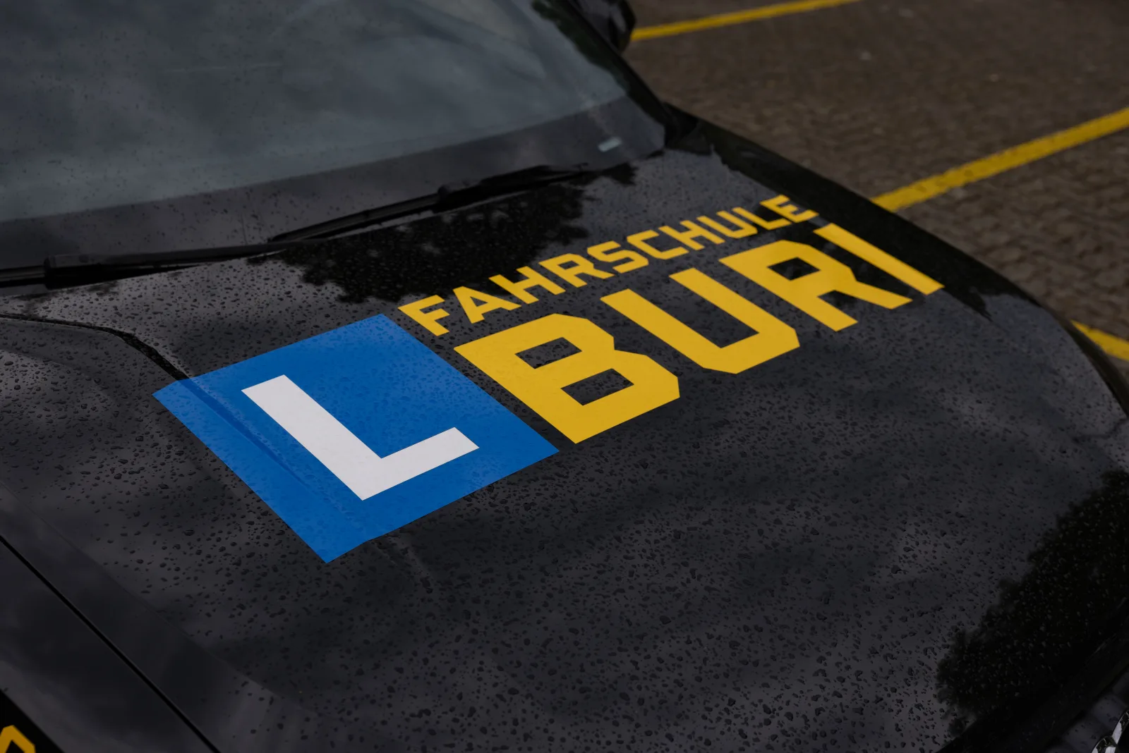 Junger Fahrer hinter dem Steuer seines ersten Fahrzeugs